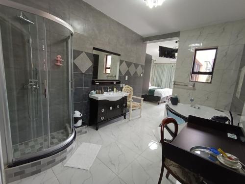 a bathroom with a shower and two sinks and a shower at Manasseh Guesthouse in Gaborone