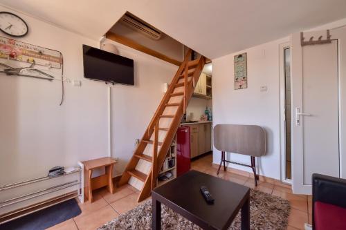 a living room with a staircase and a tv at Anne Apartament in Năvodari