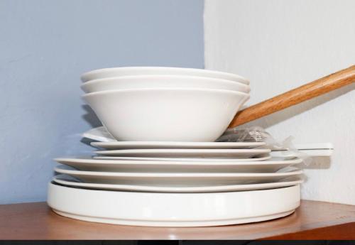a stack of white plates sitting on a table at Villa La Fortuna B&B Altos del Maria in Filipina