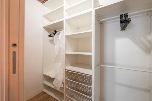 een kast met witte planken en een koelkast bij [Quadrilatero Loft] Elegant Stay in Turijn