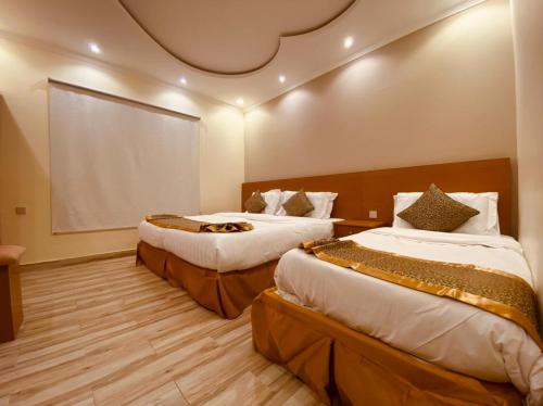 麥地那的住宿－Oasis Residential，酒店客房设有两张床和大窗户。