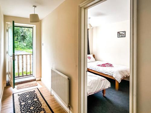 a small bedroom with a bed and a window at Woodside Fishery - The Plover in Cleobury Mortimer