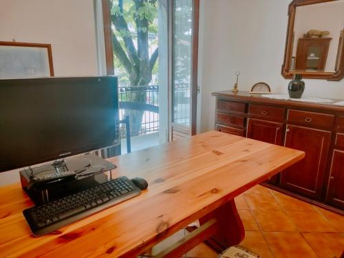 a desk with a computer monitor and a keyboard on it at Casa Valda in Fanano