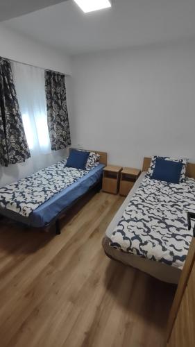 2 letti posti in una stanza con pavimenti in legno di Apartamento Horizonte Azul Cullera a Cullera