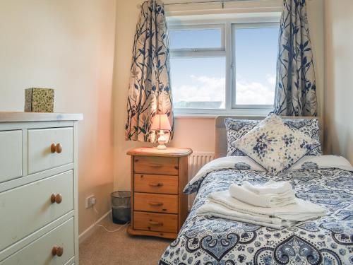 a bedroom with a bed with a window and a dresser at Woodlander in Dorchester