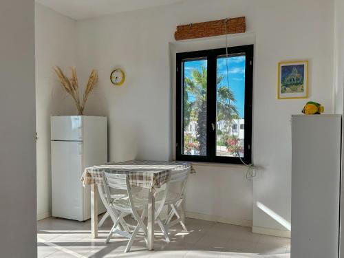 uma cozinha com uma mesa, um frigorífico e uma janela em Puglia Villa Mare Gargano Manfredonia em Zapponeta