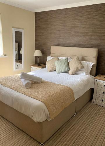 a bedroom with a large bed and a mirror at Abercrave Inn in Abercraf