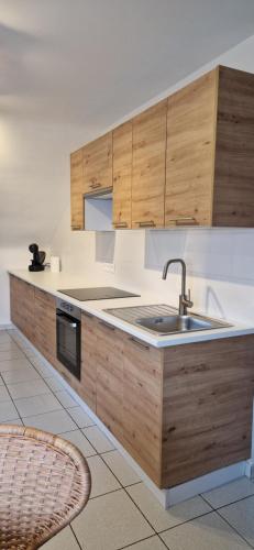 a kitchen with wooden cabinets and a sink at Trudo Loft in Sint-Truiden