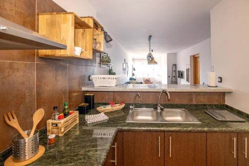 a kitchen with a stainless steel sink and wooden cabinets at Primera línea de playa Radazul in Radazul