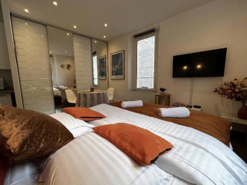 a bedroom with two beds and a television on the wall at Appartement - Cannes vieille ville - Le Suquet in Cannes