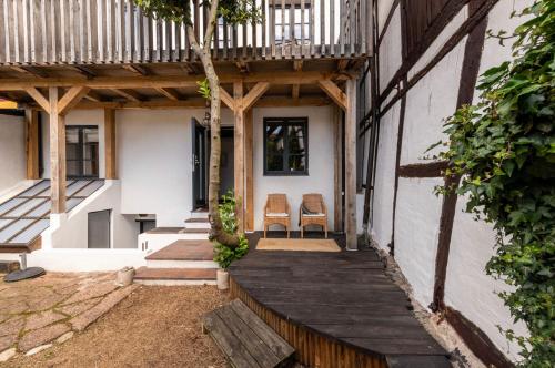 a porch of a house with two chairs on it at Rooms in the center of Ystad in Ystad