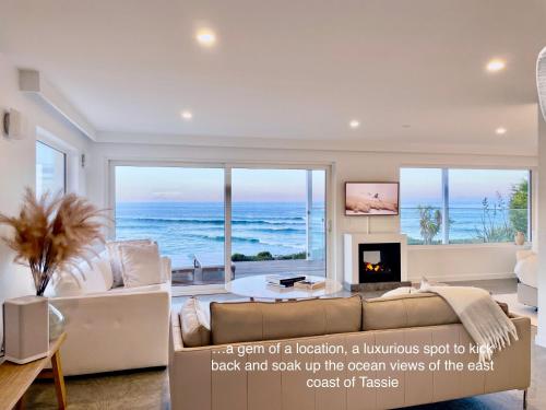 a living room with a view of the ocean at Saltwater - Absolute Oceanfront, Hot Tubs, Sauna, Fire Pits in Falmouth