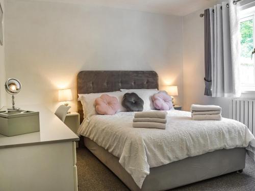 a bedroom with a bed with pink pillows on it at Kennet Valley View in Tilehurst