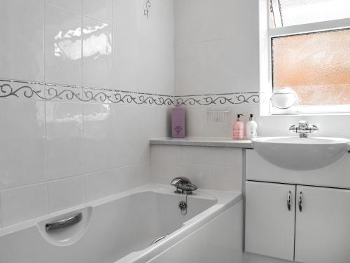 a white bathroom with a sink and a bath tub at Kennet Valley View in Tilehurst