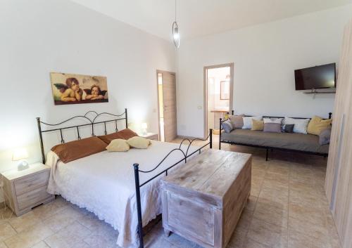 セルヴァ・ディ・ファザーノにあるvilla Bagordaのベッドルーム(ベッド1台、ソファ付)