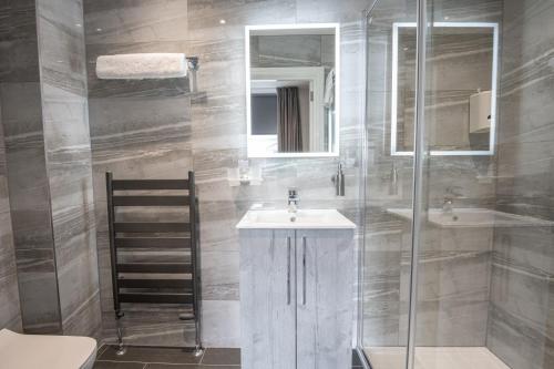 een badkamer met een wastafel en een glazen douche bij The Fort Hotel in Dundee