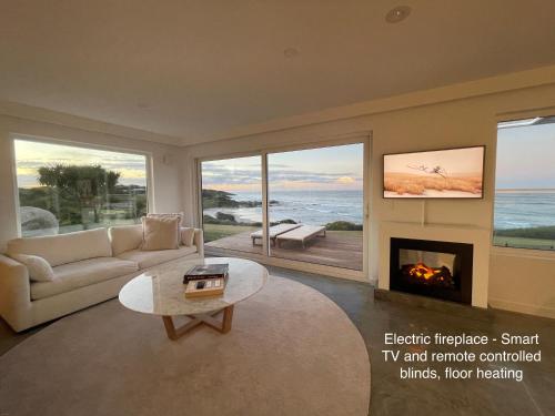 a living room with a couch and a fireplace at Saltwater - Absolute Oceanfront, Fire Pits, some Villas with Hot Tubs and Sauna in Falmouth