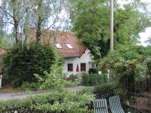 a white house with two chairs in front of it at Ferienwohnung-Geltendorf Nähe Ammersee in Geltendorf