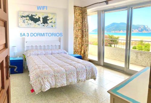 a bedroom with a bed with a view of the ocean at Apartment Laredo Sea Beach in Laredo