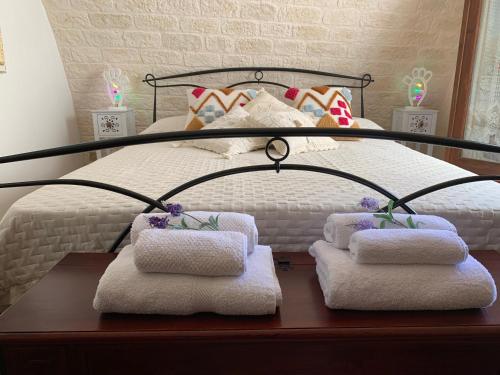 1 dormitorio con 1 cama y toallas en una mesa en Terratetto Locorotondo Sweet Guest House en Locorotondo