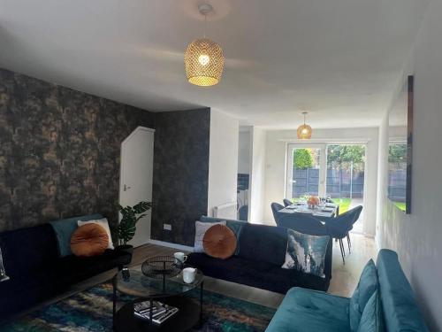 - un salon avec un canapé bleu et une table dans l'établissement CAPRI 13 SA- Nice ’n’ New, close to Uni and M1/J23, à Loughborough