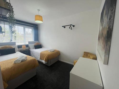a room with two beds and a table in it at CAPRI 13 SA's 3 bedroom home, close to Loughborough University and M1 in Loughborough