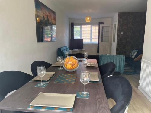 a dining room table with a bowl of fruit and wine glasses at CAPRI 13 SA's 3 bedroom home, close to Loughborough University and M1 in Loughborough