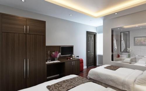 a bedroom with two beds and a television and a tub at Eco Luxury Hotel Hanoi in Hanoi