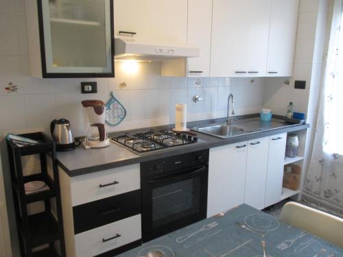 a small kitchen with a stove and a sink at Margin - Appartamento vicino al centro in Genoa