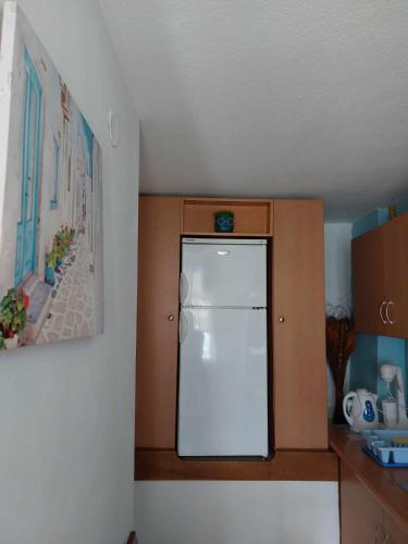 a kitchen with a white refrigerator in a room at Violetta Studios & Apartments in Milína