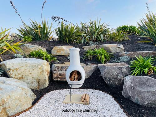 Un jarrón con un gato sentado junto a unas rocas en Saltwater - Absolute Oceanfront, Hot Tubs, Sauna, Fire Pits, en Falmouth