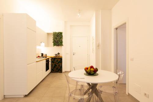 eine weiße Küche mit einem weißen Tisch und Stühlen in der Unterkunft Brenta Top Floor - MM3 Yellow Line in Mailand