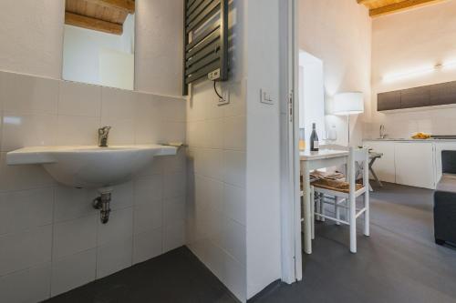 a white bathroom with a sink and a kitchen at Terrazze dell'Etna - Country rooms and apartments in Randazzo