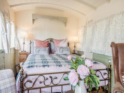 a bedroom with a bed with a vase of flowers at Just The Ticket - Uk44791 in Barney