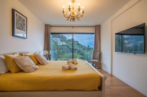 sypialnia z dużym żółtym łóżkiem z żyrandolem w obiekcie Gold Villa w Funchal