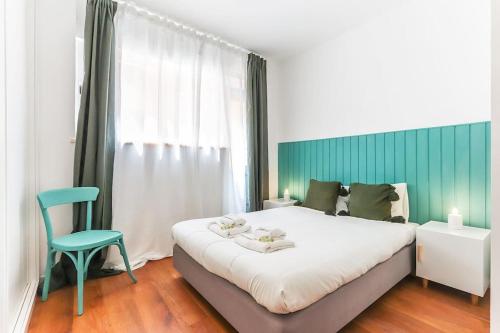 a bedroom with a bed and a blue chair at Vita Portucale ! Bright Campo Ourique w/ Terrace in Lisbon