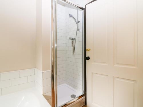 um chuveiro com uma porta de vidro na casa de banho em The Old Laundry Cottage em Perth