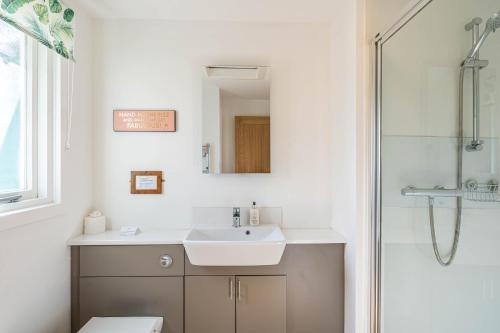 a bathroom with a sink and a shower at Bracken Lodge 15 with Hot Tub in Belladrum