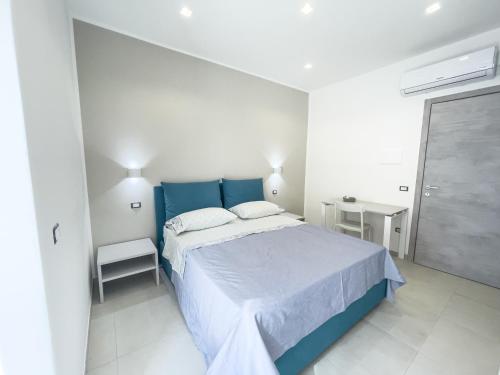 a bedroom with a blue bed in a white room at Villa Marisa - Villa di Lusso Fronte Spiaggia in Cittadella del Capo