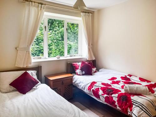 a bedroom with two beds and a window at Woodside Fishery - Kingfisher in Cleobury Mortimer