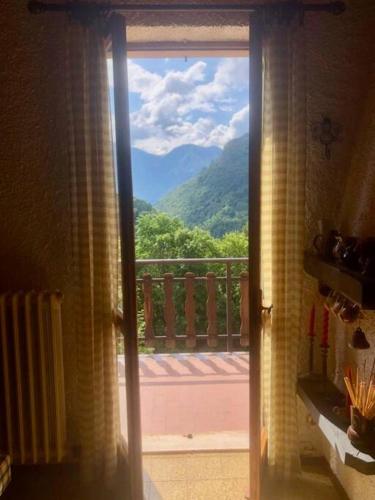 a door to a balcony with a view of a mountain at Appartamento panoramico Casa Gerro in Averara