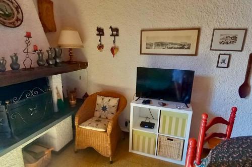 a living room with a tv and a chair at Appartamento panoramico Casa Gerro in Averara