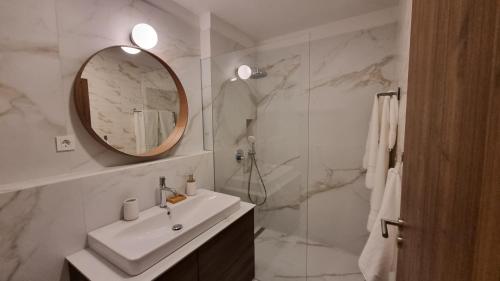 a bathroom with a sink and a mirror and a shower at Delta House - Alfa apartment in Zadar