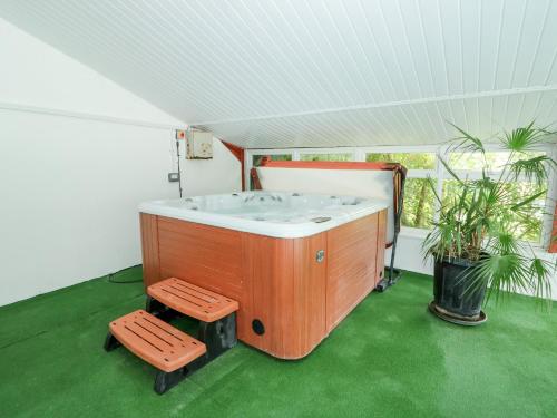 a bath tub in a room with a green floor at Fernleigh Villa Annexe in Wisbech