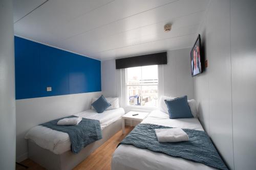 a small room with two beds and a window at CiTi Hotel London Luton in Luton
