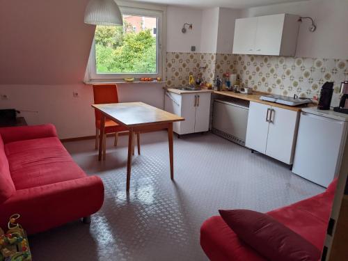 una pequeña cocina con mesa y sofá rojo en Monkey Factory - Mini Home-Stay Hostel, en Traben-Trarbach