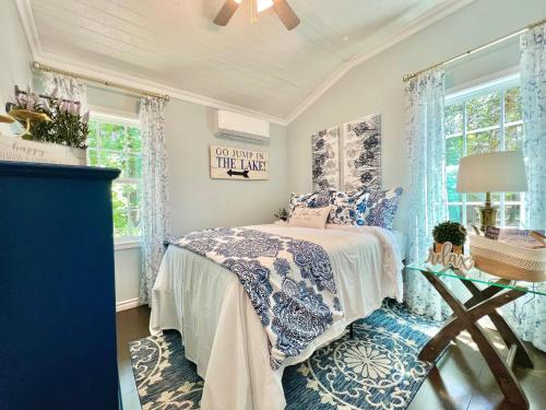 a blue and white bedroom with a bed and windows at SLEEPS SIX - Rent Entire WATERFRONT CABIN #1 in Etoile