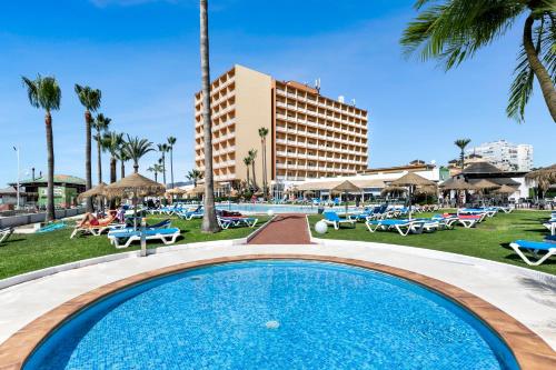 una piscina en un complejo con sillas y un hotel en Sol Guadalmar en Málaga