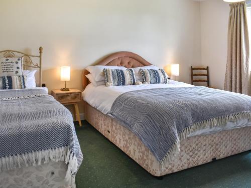 a bedroom with two beds and two lamps at The Old Byre in Haswell