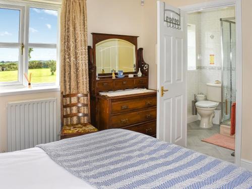 The Old Byre في Haswell: غرفة نوم مع حمام مع حوض ومرآة